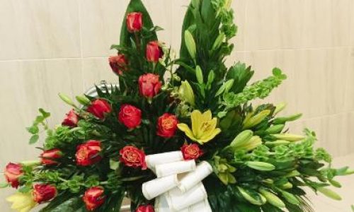 Palma rosas naranjas y lilium amarillo